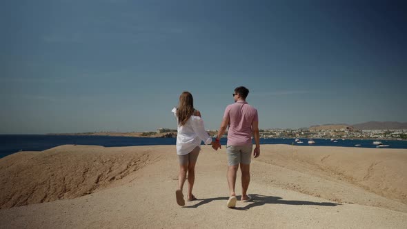 Romantic Date Near Sea Man and Woman are Walking and Holding Hands Enjoying Seascape