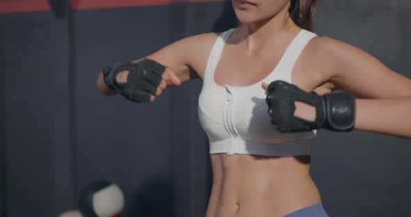 woman boxer standing inside a boxing gym fitness club studio with her punch hands