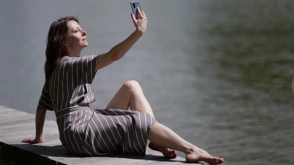 Charming Adult Woman is Photographing Her Face for Social Nets Take Selfie By Smartphone