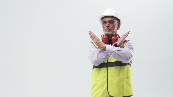 Adult engineer in working uniform shows the cross with hands and shakes head negatively