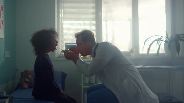 Doctor Examining Girl Throat in Clinic