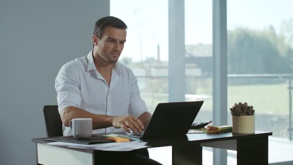 Business Man Working at Laptop Computer. Positive Freelancer Preparing Documents