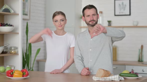 Woman and Man Showing Thumbs Down Sign