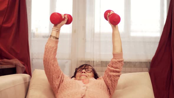 Old Granny Training Dumbbells On Home. Senior Woman Sport Workout Weight Lifting. Exercising Sport.