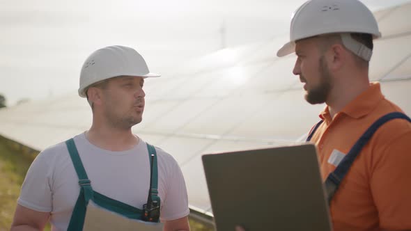 Crop View of Diverse Male Engineers Standing at Solar Farm and Discussing