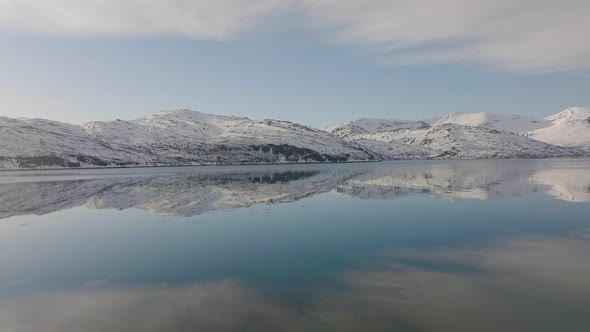 snowy mountain reflections on water. Cold landscape reflex. blue reflexion clouds