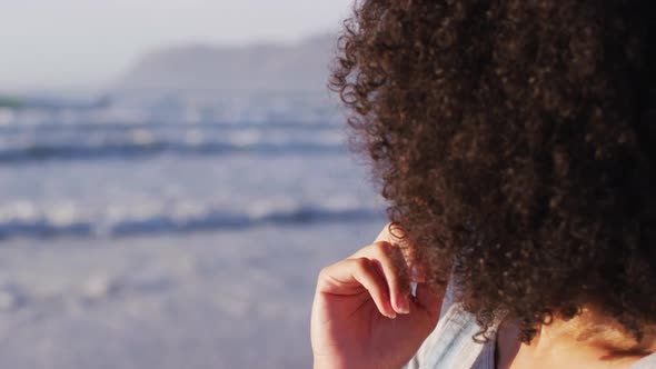 Close of up of african american with hand on chin smiling at the beach