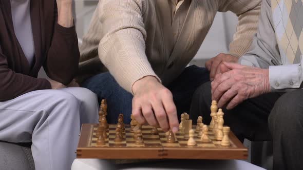 Group of Seniors Playing Chess at Nursing Home, Enjoying Leisure Time Together