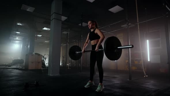 Female Bodybuilder Doing Exercise with Weights in Gym