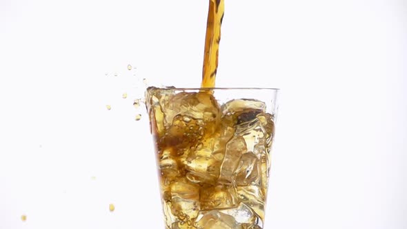 Pouring Cola into a Glass with the Ice Cubes