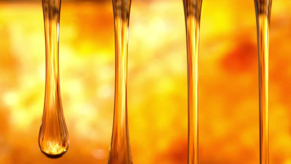 Super Slow Motion Macro Shot of Dripping Honey on Golden Honeycomb Background at 1000 Fps