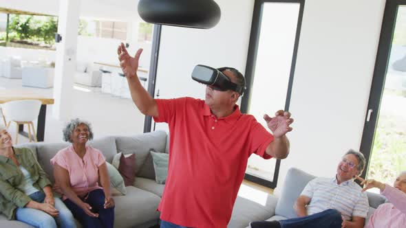 Happy senior diverse people using vr headset at retirement home