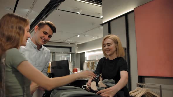 Dolly Camera of Caucasian Blondie Cashier Taking Cloth for Packing