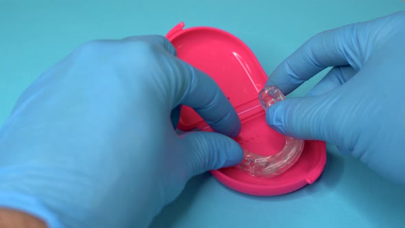 Doctor Putting a Dental Retainer or Dental Splint From a Pink Boxset