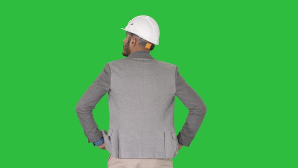 Engineer standing and looking around on a Green Screen, Chroma Key.