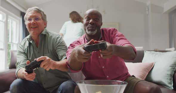 Animation of happy diverse male senior friends playing video games