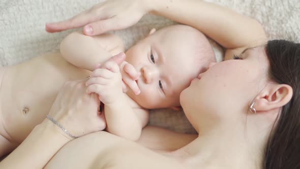 a Naked Mother and the Baby on the Bed