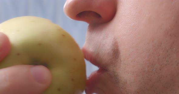 A Person Bites Off an Apple Closeup