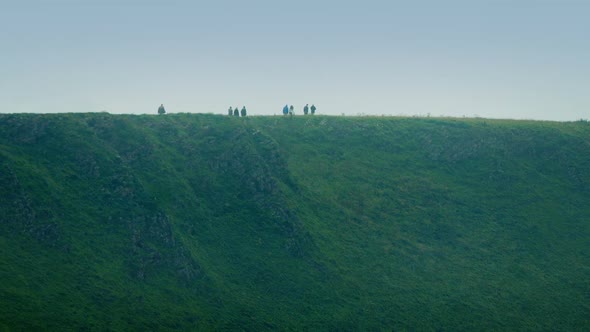 People Walking Along Hilltop