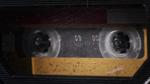 Vintage Yellow Audio Cassette Tape Rotates in Deck of an Old Tape Recorder