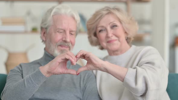 Old Couple Holding Hands Together in Heart Shape