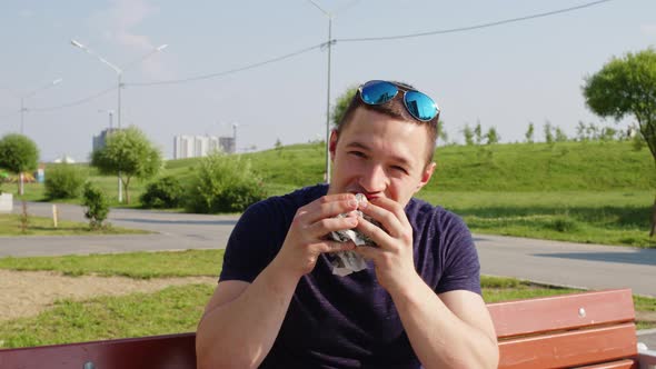 A Man Biting Hamburger with Great Appetite