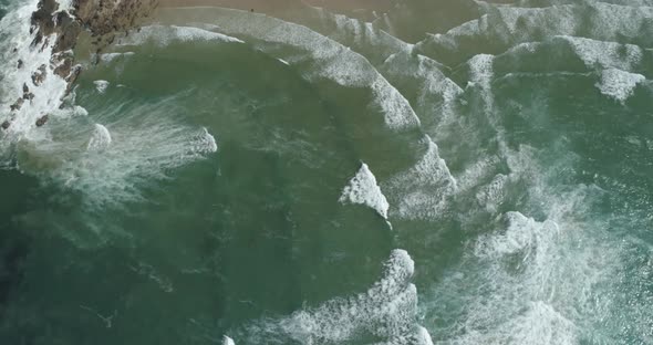 Aerial view of the blue waves near the coast of a beautiful tropical island.