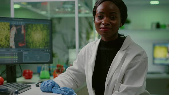 Portrait of Biologist Researcher Woman in White Coat Looking Into Camera