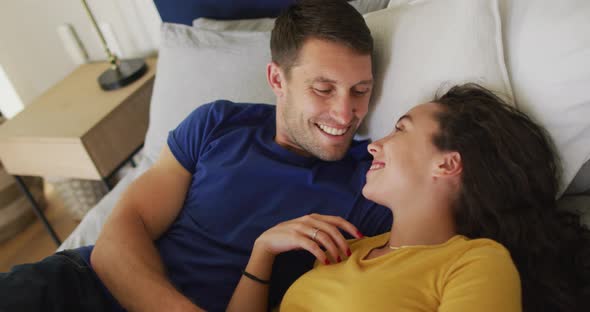 Happy caucasian couple in love resting and kissing in bed