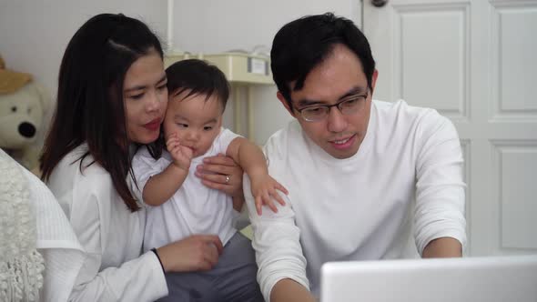 Father Working Using Laptop with His Wife and Cute Boy While Sitting on Floor in Cozy Room at Home