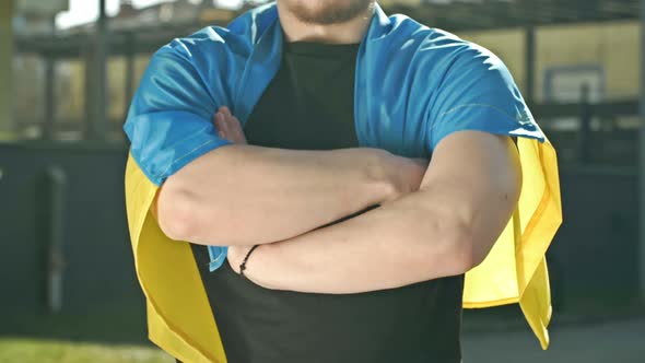 Man with the Ukrainian Flag on His Shoulders and the Emblem of Ukraine on a Tshirt