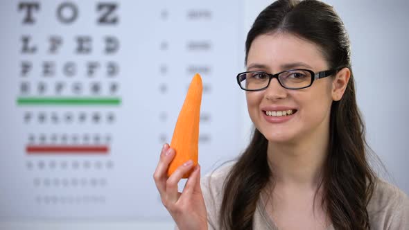 Smiling Female in Eyeglasses Biting Fresh Carrot, Useful Vitamins and Minerals