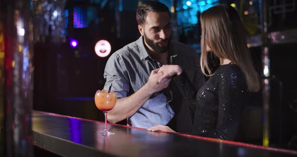 Portrait of Young Middle Eastern Man and Caucasian Woman Meeting Each Other in Night Club. Cheerful