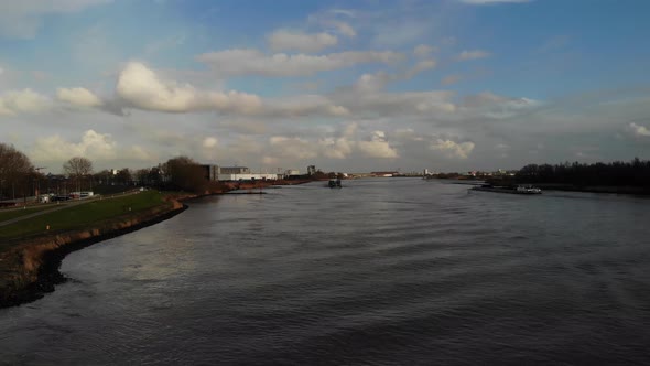 Scenic View With Cargo Vessels Sailing Across Quiet River Of Oude Maas In The City Of Zwijndrecht, N
