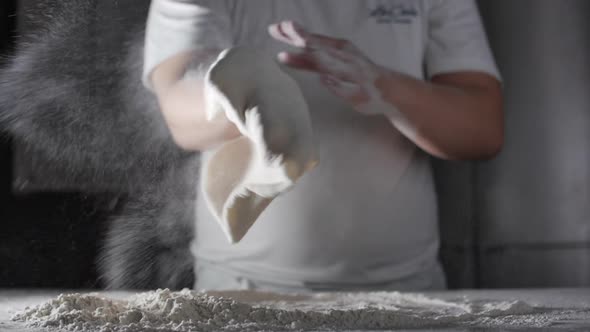 Flour Falls From the Hands of an Italian Chef in a Professional Kitchen Preparing a Dough with Flour