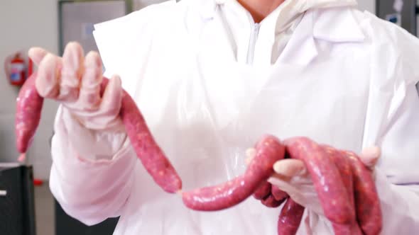 Female butcher holding sausages
