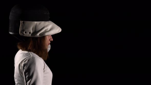 Side View of Young Female Fencer Puts Sports Mask Helmet and Performing an Opponent Attack Technique