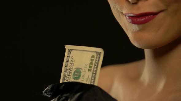 Elegant Lady Showing Bunch of Dollars Into Camera Isolated on Black Background