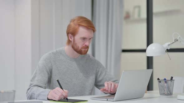 Redhead Graphic Designer Using Laptop and Tablet