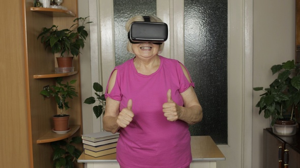 Senior Grandmother Woman in Virtual Headset Glasses Watching 3d Video in 360 Vr Helmet at Home