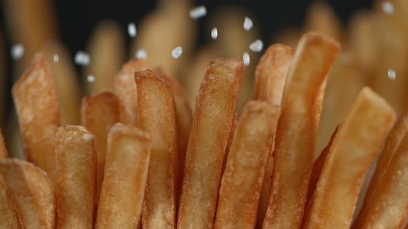 Super Slow Motion Detail Shot of Adding Salt on Fresh French Fries at 1000Fps