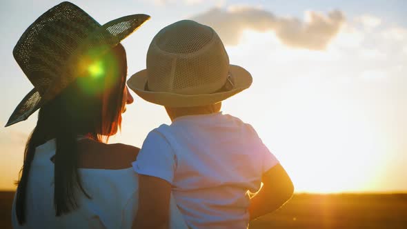 Happy Family Mom and Little Son at Sunset Silhouette