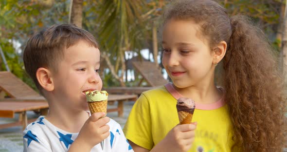 Smiling Children Happy Little Boy and Girl Eating Ice Cream and Having Fun Looking at Each Other