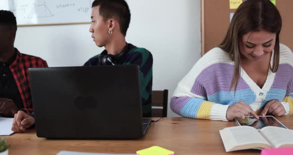 Multiracial students using laptop and digital tablet while studying together - School concept