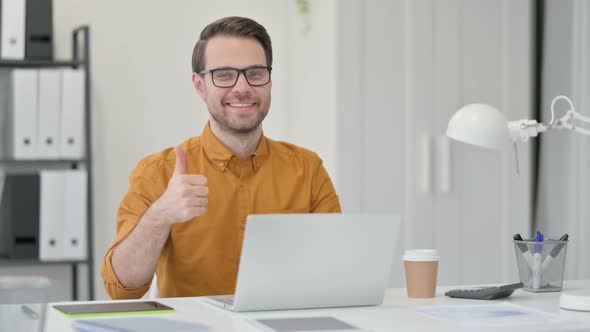 Thumbs Up By Young Man with Laptop 