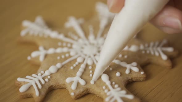 Close-up of a woman decorating a homemade gingerbread Snowflake