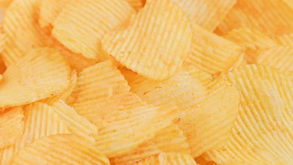 Looped Spinning Yellow Wavy Potato Chips Full Frame Closeup Background