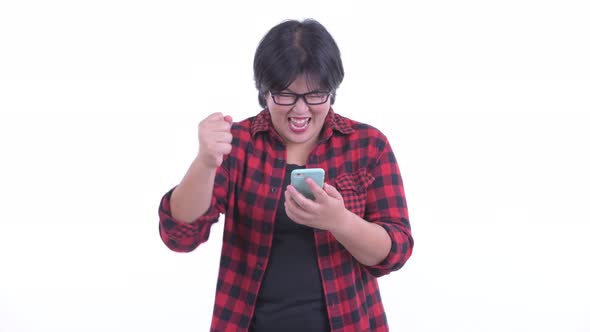 Happy Overweight Asian Hipster Woman Using Phone and Getting Good News