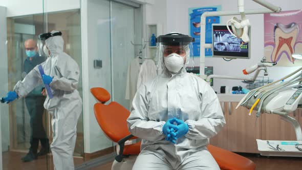 Dentist with Coverall Looking at Camera Talking with Patients