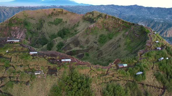 cafes along the crater rim and ridge of Mount Batur volcano in Bali Indonesia during sunrise, aerial